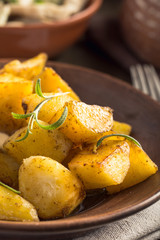 Baked potato with rosemary on plate vertical