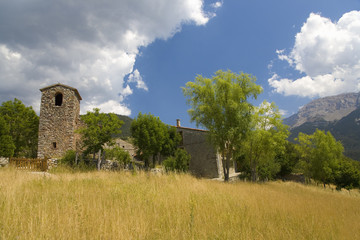 Fototapeta premium Old church tower and blue sky in Pyrenees Mountains, near La Seu d'Urgell, Cataluna, and Ansovell, province of Lleida, off N-260 Road, Spain, Europe