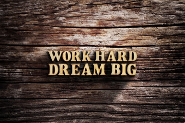 Work hard dream big. Words on old wooden board.