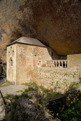 The Monastery of San Juan de la Pena, Jaca, in Jaca, Huesca, Spain, carved from stone under a great cliff.  It was originally built in 920 AD and in 11th Century, became part of Benedictine Order, the site thought to house the legendary Last Supper "Holy Grail" and associated with the legend of "Monte Pano"