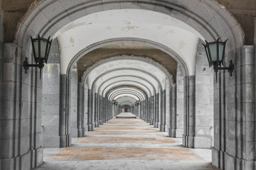 Symmetrical corridor with rows of columns. Black and white picture.