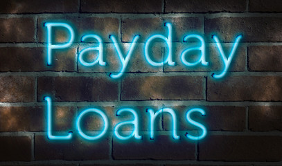 Blue neon sign on a brick wall "payday loans"
