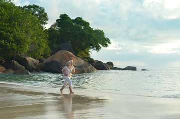 Fototapeta premium Elderly couple running on beach