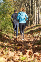 Fototapeta premium Young running couple jogging in autumn nature