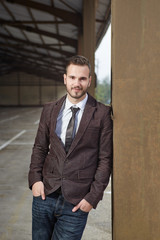 Smiling business man standing outside office building