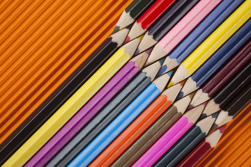 coloring pencils top view shot diagonally with negative space on an orange background landscape