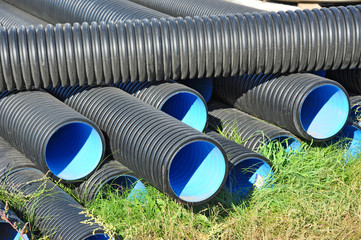 Stacked new PVC pipe on construction site