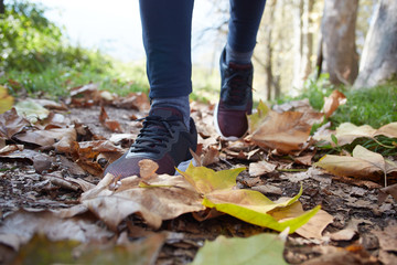 close up of feet of a runner running in autumn leaves training f