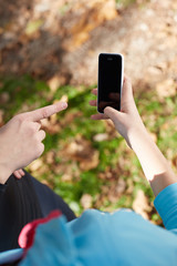 Young woman relaxing after jogging.She using her smart phone and