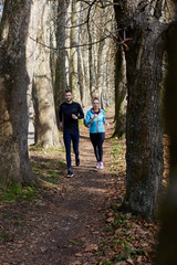 Fototapeta premium Young couple running together in park - fall nature