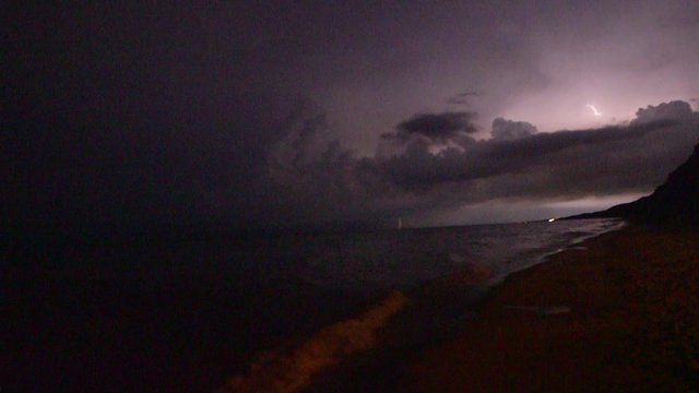 Thunderstorm and lightning flashes along coastline waterfront