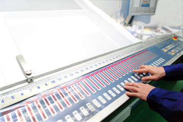 オフセット印刷の色見台で操作する作業員