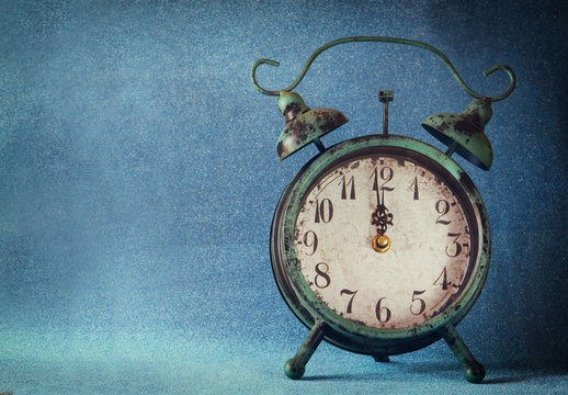 vintage clock over blue ice bokeh background. new year concept. selective focus
