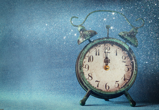 vintage clock over blue ice bokeh background. new year concept. selective focus
