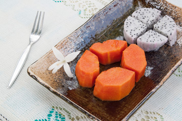 papayas and dragon fruit on table cloth
