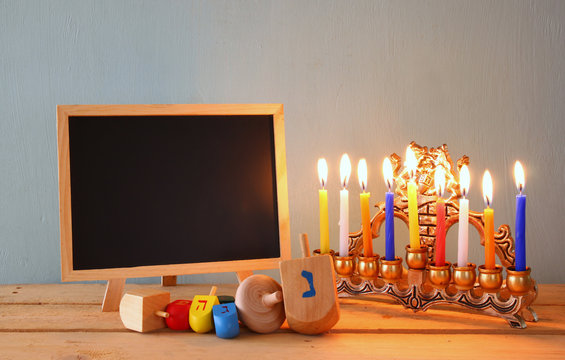 
image of jewish holiday Hanukkah with wooden colorful dreidels (spinning top) with chalkboard background
