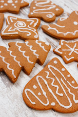 Fresh baked decorated gingerbread on old wooden background, christmas time