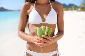 Aloe Vera - woman showing plant for skin care treatment using Aloes. Can be used as natural medicine or remedy against sunburn. - obrazy, fototapety, plakaty