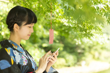 若い女性　浴衣　和服　黒髪　スマホ　風鈴　横顔　書中見舞いイメージ