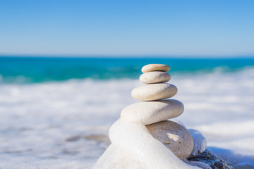 Stones pyramid on sand symbolizing zen, harmony, balance. Ocean