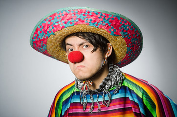 Man in vivid mexican poncho against gray