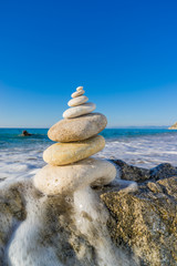 Stones pyramid on sand symbolizing zen, harmony, balance. Ocean