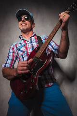 Fototapeta premium happy senior guitarist having fun playing an electric guitar