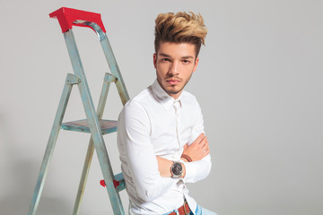 portrait of man leaning against a ladder with hands crossed