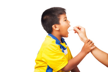 Mother giving boy medicine, cough syrup on a spoon. Sick kid
