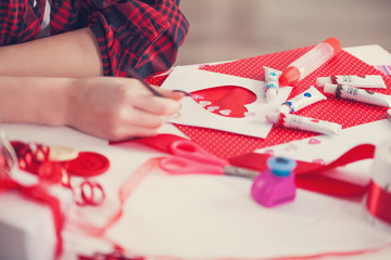 Woman creating gift at home with paper and gouache