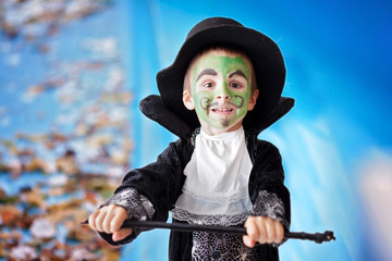 Cute boy with painted face as a lion, having fun