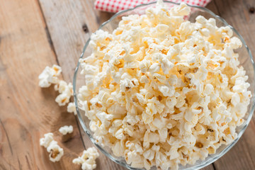 Bowl of popcorn on wood table. Top view.