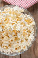 Bowl of popcorn on wood table.