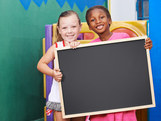 Kinder halten leere Tafel in der Vorschule