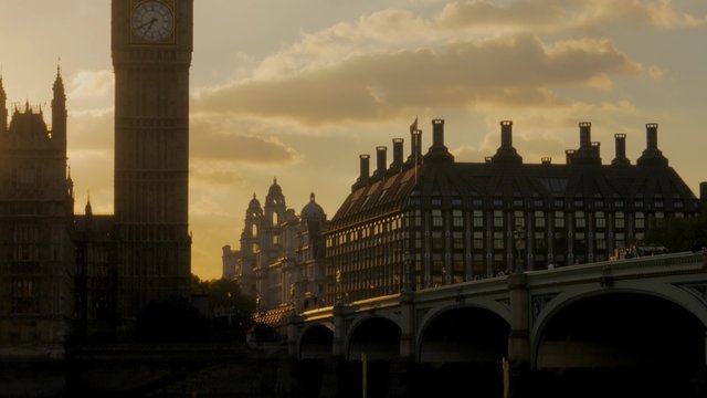 Tilt shot down Big Ben to the River Thames as the sun sets behind parliament
