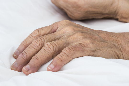Old hands on the bed
