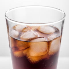 Cola glass with ice cubes on a white background