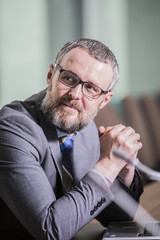 closeup bearded businessman smiling while sitting at the conference table