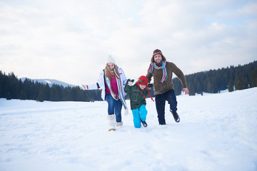 happy family playing together in snow at winter