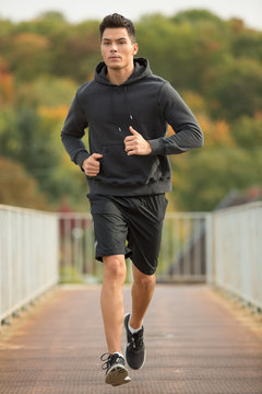 Junger Mann joggt im Herbstwald