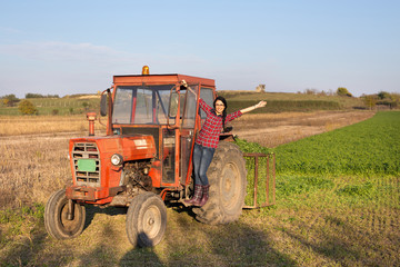 Obraz premium Girl in the tractor on farmland