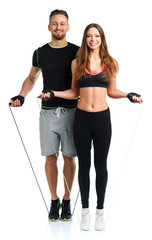 Happy athletic couple - man and woman with with ropes on the whi