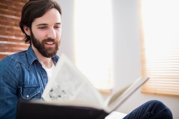 Naklejka premium Casual man reading on his sofa
