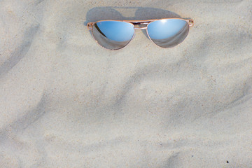 Sunglasses lying on the beach, white sand