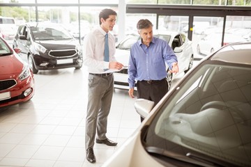 A man showing a car to the salesman