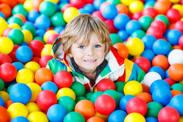 Fototapeta na wymiar child playing at colorful plastic balls playground