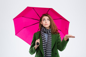 Woman in coat and scarf holding umbrella