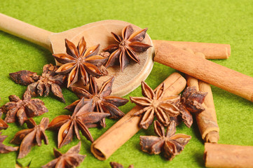 cinnamon and asterisk on wooden Spoon with green background (soft focus , lens blur)