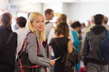 Young blond caucsian woman waiting in line.