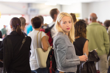 Young blond caucsian woman waiting in line.